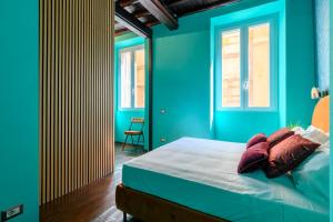 a bedroom with blue walls and a bed with pillows at Riad De’ Fiori in Rome