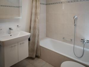 y baño con bañera, lavamanos y ducha. en Apartment Davinci by Interhome en Täsch