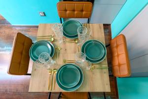 uma mesa com pratos verdes e copos de vinho em Riad De’ Fiori em Roma