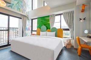 a bedroom with a large white bed and a desk at 星澄風旅 Zela Design Hotel in Kaohsiung