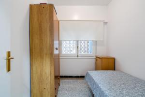 een kleine slaapkamer met een bed en een raam bij Aubi in Palamós