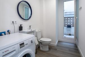 a white bathroom with a toilet and a mirror at Aubi in Palamós +9 photos