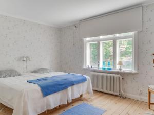 Un dormitorio blanco con una cama y una ventana. en Holiday Home Norrgården by Interhome, en Lekeryd