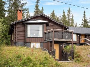 a wooden house with a deck on a hill at Chalet Korpstigen Renen - DAN074 by Interhome in Sälen