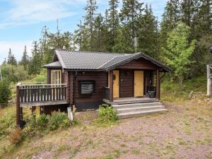 a small cabin with a porch and a deck at Chalet Korpstigen Renen - DAN074 by Interhome in Sälen