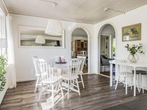a dining room with white chairs and a table at Holiday Home Ryedal by Interhome in Svängsta