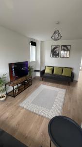a living room with a couch and a tv at Supreme Apartments in Keighley