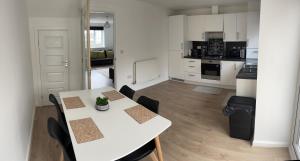 a kitchen with a white table and chairs in a room at Supreme Apartments in Keighley