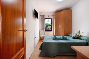 Villa Malva في كوراليخو: غرفة نوم صغيرة مع سرير وخزانة