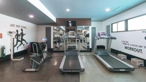 a gym with treadmills and machines in a room at RedDoorz Premium at The Residences Olympia Makati in Manila