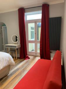 a bedroom with a red couch in front of a window at Entire apartment in central Brighton in Brighton & Hove