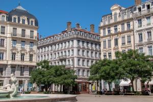 un grupo de grandes edificios con una fuente frente a ella en Mercure Lyon Centre Beaux-Arts, en Lyon