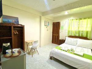 WHITEBEACH DE BORACAY STATION 1 (EXTENSION) في بوراكاي: غرفة نوم بسرير وطاولة مع كرسي