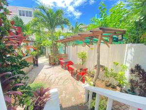 un patio con sillas rojas y pérgola de madera en WHITEBEACH DE BORACAY STATION 1 (EXTENSION) en Boracay