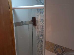 y baño con ducha y puerta de cristal. en Casarão da Ducha Hotel, en Campos do Jordão
