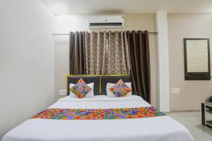 a bedroom with a large bed in front of a window at FabHotel Paradise Stay Inn in Nagpur