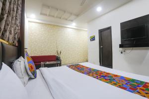 a hotel room with a bed and a chair at FabHotel Paradise Stay Inn in Nagpur