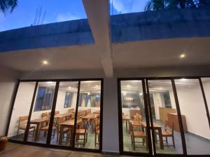 a house with glass windows and a wooden table at Atmani waterfront resort in Cola