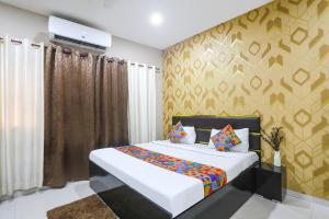 a bedroom with a large bed and a wall at FabHotel Paradise Stay Inn in Nagpur