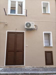 een gebouw met een deur, een raam en een ventilator bij Casuzza bedda in Casteldaccia