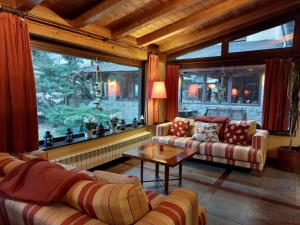 a living room with couches and a table and a window at Hotel Saurat in Espot