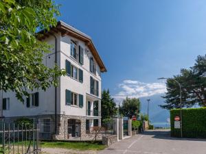 a white building with a gate in front of it at Apartment Serenella by Interhome in Gravedona