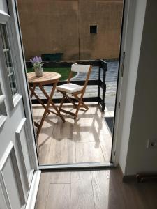 een patio met een tafel en een stoel naast een deur bij BM Apartman in Gornji Milanovac