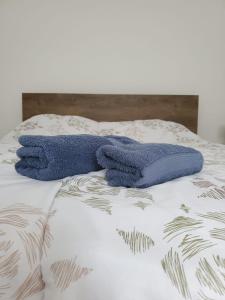 een blauwe handdoek bovenop een bed bij BM Apartman in Gornji Milanovac