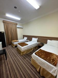 a hotel room with two beds in a room at فندق المقام السامي للغرف والشقق المفروشة in Makkah