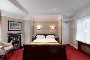 um quarto com uma cama grande e uma lareira em Wynn's Hotel em Dublin