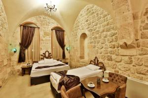 sypialnia z 2 łóżkami i stołem w pokoju w obiekcie Gazi Konagi Butik Hotel w mieście Mardin