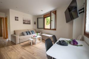 een woonkamer met een bank en een tafel bij Apartamentos Spa Las Caldas y Spa El Balneario in Oviedo