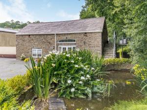 a stone building with a garden in front of it at Garden Apartment in Llandysul +7 photos
