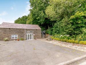 a brick barn with a driveway in front of it at Garden apartment in Llandysul