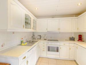 a white kitchen with white cabinets and a sink at Garden apartment in Llandysul