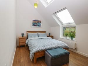 a bedroom with a bed and a window at Hen Gapel in Caernarfon