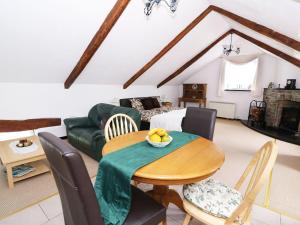 a living room with a table and chairs and a couch at Loft apartment in Llandysul