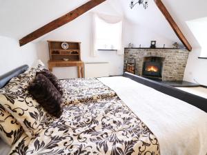 a bedroom with a bed and a fireplace at Loft apartment in Llandysul