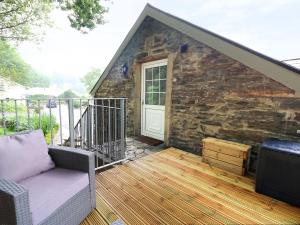 a porch with a couch on a wooden deck at Loft apartment in Llandysul