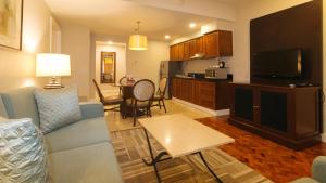 a living room with a blue couch and a kitchen at RedDoorz Premium at The Residences Olympia Makati in Manila