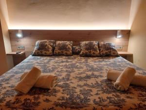 a large bed with pillows on top of it at Hotel Saurat in Espot