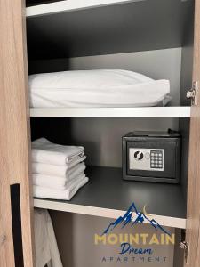 uma prateleira com uma cama, um relógio e toalhas em Fully Equiped, Quiet, for 5 persons, Next To Panoramic Gondola em Brzeće