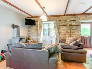 a living room with two couches and a stone wall at The Stable in Llandysul