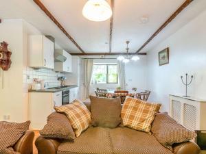 a living room with a couch and a kitchen at The Stable in Llandysul
