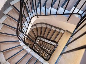 un escalier en colimaçon avec rampe en métal noir dans l'établissement Mercure Nice Centre Grimaldi, à Nice