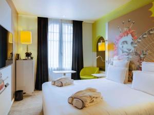Una habitación de hotel con una cama grande con dos bolsas. en Mercure Nice Centre Grimaldi, en Niza