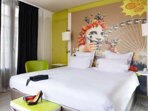 a hotel room with a large bed with a clown on the wall at Mercure Nice Centre Grimaldi in Nice