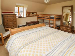 a bedroom with a bed and a dresser and bunk beds at Rowan Cottage in Shrewsbury