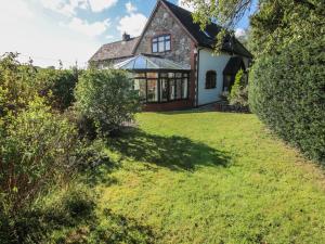 eine Außenansicht des Hauses mit Rasen in der Unterkunft Rowan Cottage in Shrewsbury