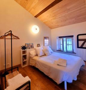 a bedroom with a large bed with a wooden ceiling at chambres d'hotes Le 1891 in Montech